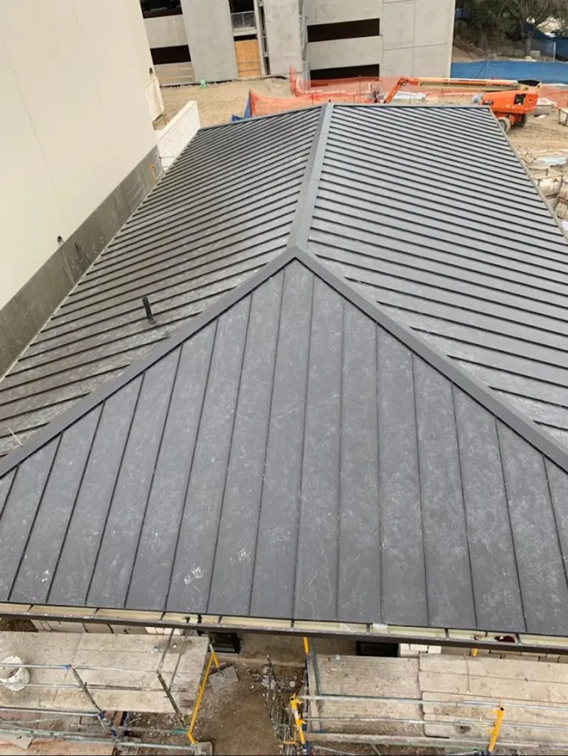 Commercial metal roof construction with crane equipment in Lone Grove