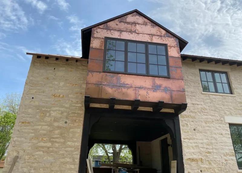 Copper metal panel facade on a stone building for Roof Repair in Lone Grove